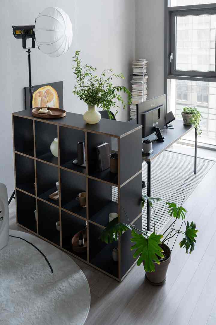 グレー調の壁と床にブラックのモジュラーシェルフと机が配置されたナチュラルモダンなホームオフィス