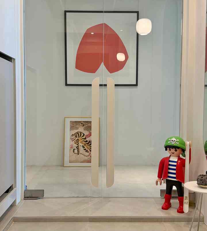 ホワイトと木目調が調和した玄関、透明なガラスドアとかわいい海賊のオブジェが配置された空間
