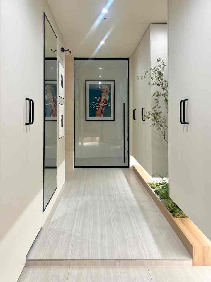 白とナチュラルカラーが調和したパントリー入口とシューズラックが配置された清潔感のある玄関スペース