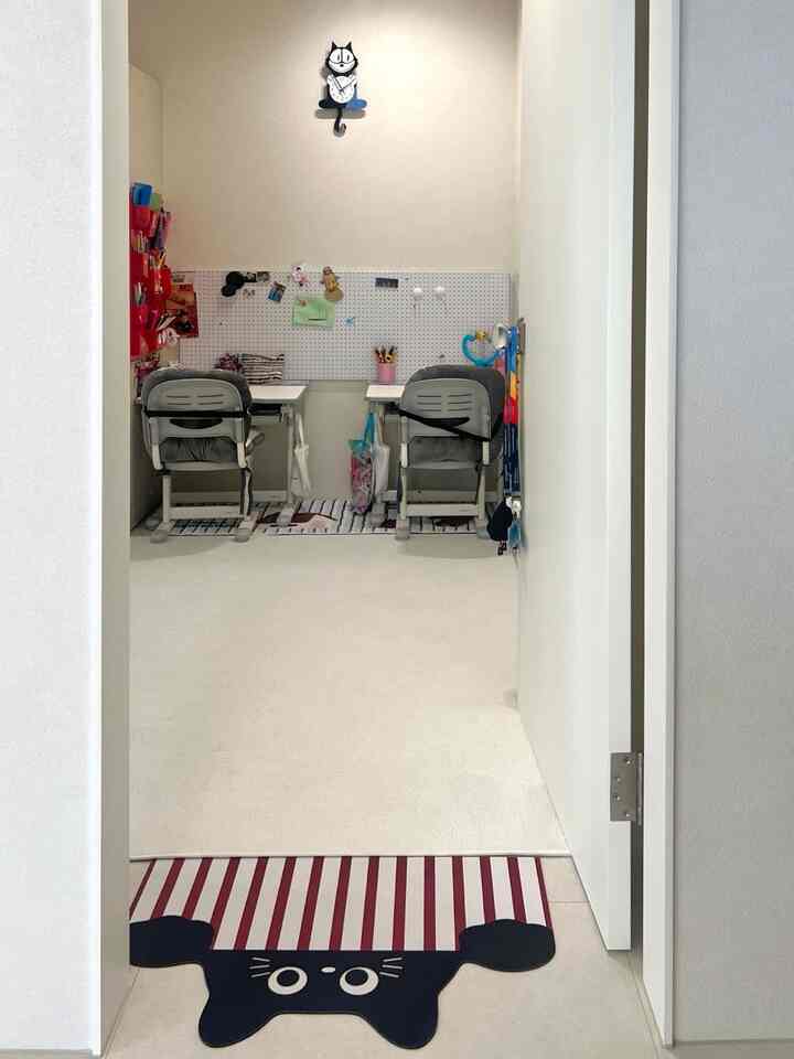 白とベージュの色調の子供部屋、二つの子供用机と椅子が整然と配置された清潔な空間