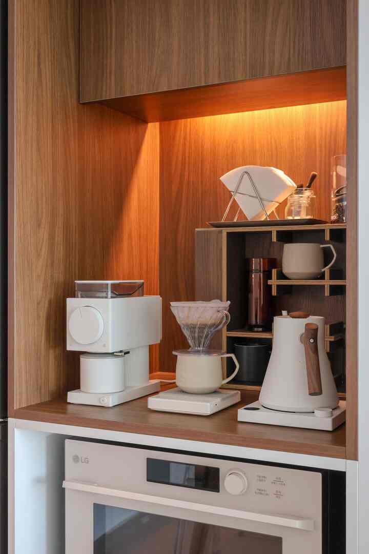 温かみのある木目調と照明があるホームバー兼おうちカフェ空間、コーヒー用品とドリップセットが整えられたミニマルなインテリア