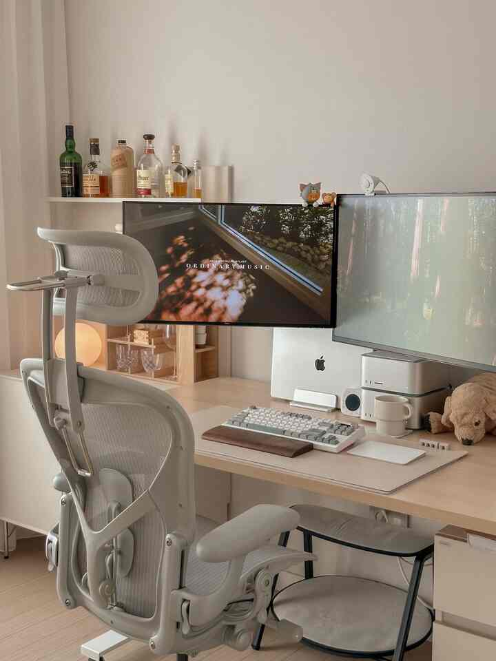 ベージュと木目調の調和があるホームオフィス書斎、デュアルモニターと人間工学チェアが配置された落ち着いた作業空間