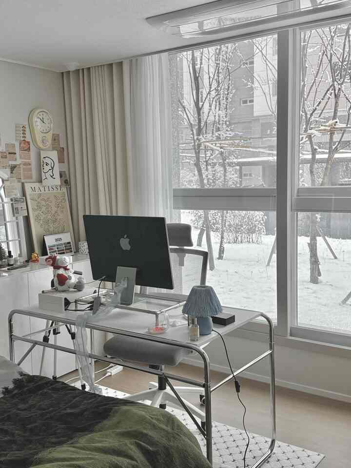 明るいホワイトとグレーの色調の寝室のホームオフィス、大きな窓とモダンな家具が配置された印象的な空間