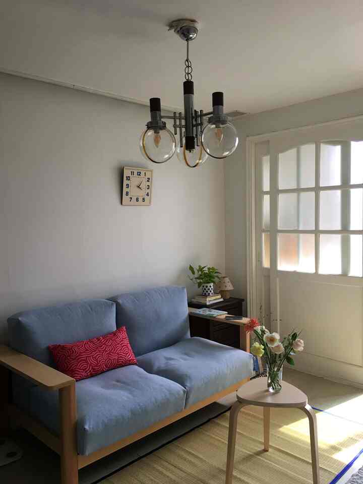 ベージュの床と青いソファが際立つ、ナチュラルな雰囲気のリビングルームインテリア。