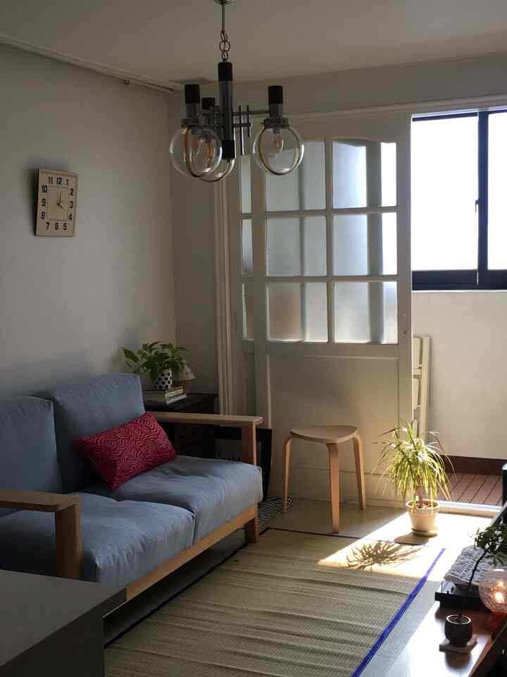 ブルーのソファとベージュのマットが配置されたナチュラルな雰囲気のリビング