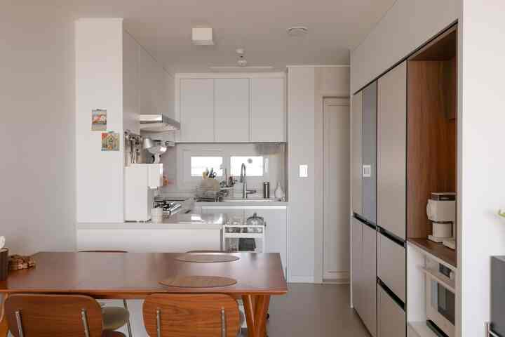 白と木目調が調和したコンパクトなキッチンとダイニング、自然で落ち着いた雰囲気のインテリア