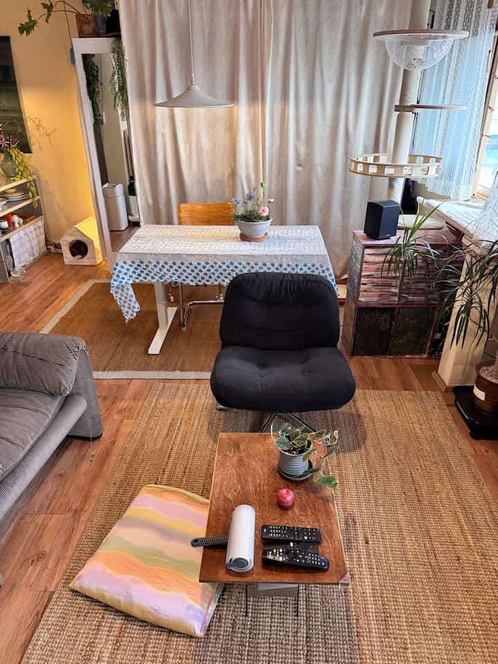 ベージュと木目調が調和した居心地の良いリビング、カーテンとソファ、アームチェア、コーヒーテーブルが配置された自然な雰囲気のインテリア