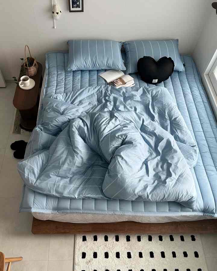 クールなブルートーンと木目調が調和したローベッドを配置したシンプルでモダンな寝室