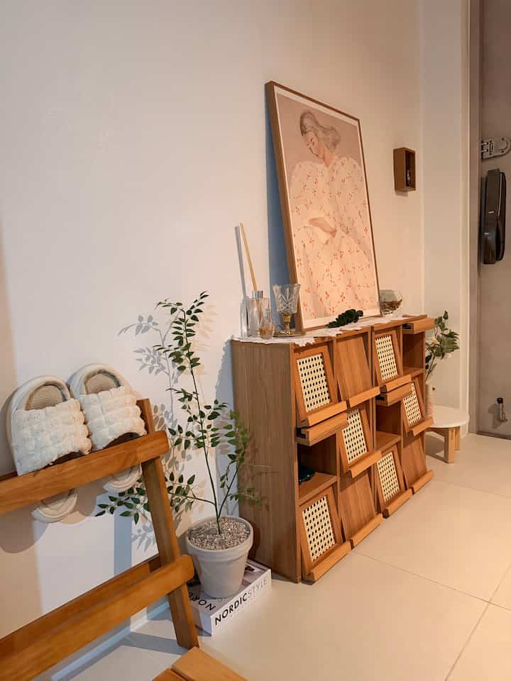 ナチュラルで木目調の玄関、暖かみのあるソフィアリンドのポスターと整理された収納家具が配された雰囲気のある空間