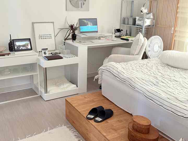 白を基調とした寝室とデスクが配置された、シンプルで落ち着いたホームオフィス空間