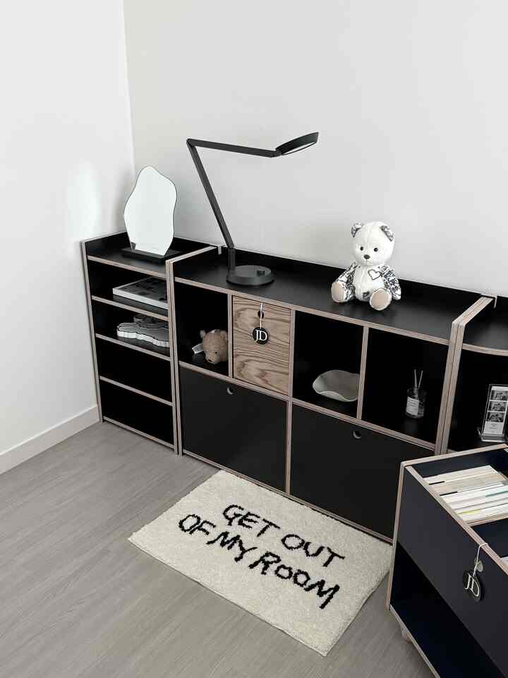 黒い収納ユニットと様々な装飾品が配置されたモダンな子供部屋