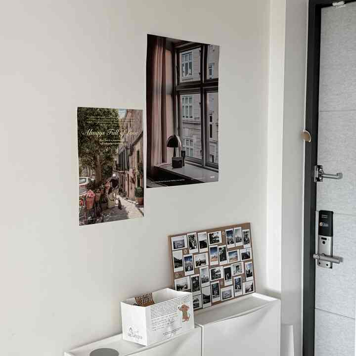 白を基調とした玄関、ポスターと写真が飾られた印象的な空間