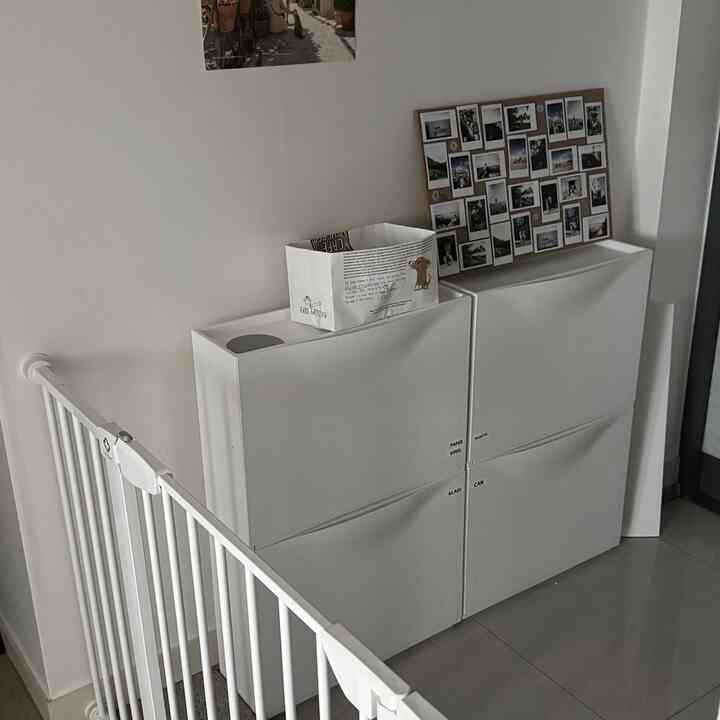 白を基調とした玄関スペース、ペット用の安全フェンスとイケアのシューズラックが配置された雰囲気のあるインテリア