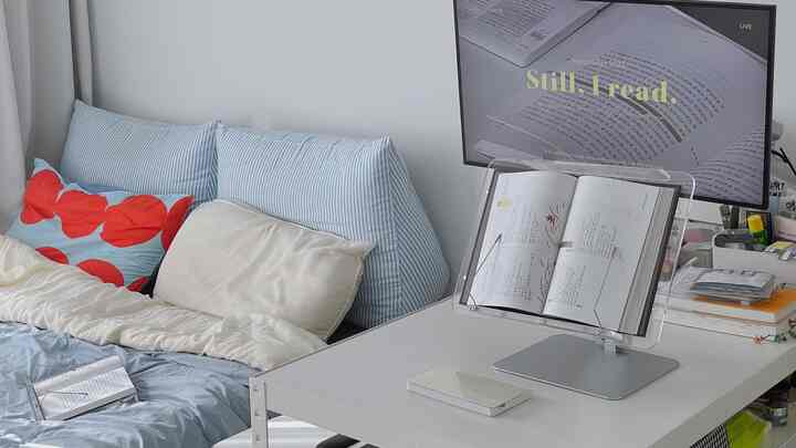 ホワイトとパステル色調の寝室とデスクが調和した、読書に集中できる清潔感のあるホームオフィス空間