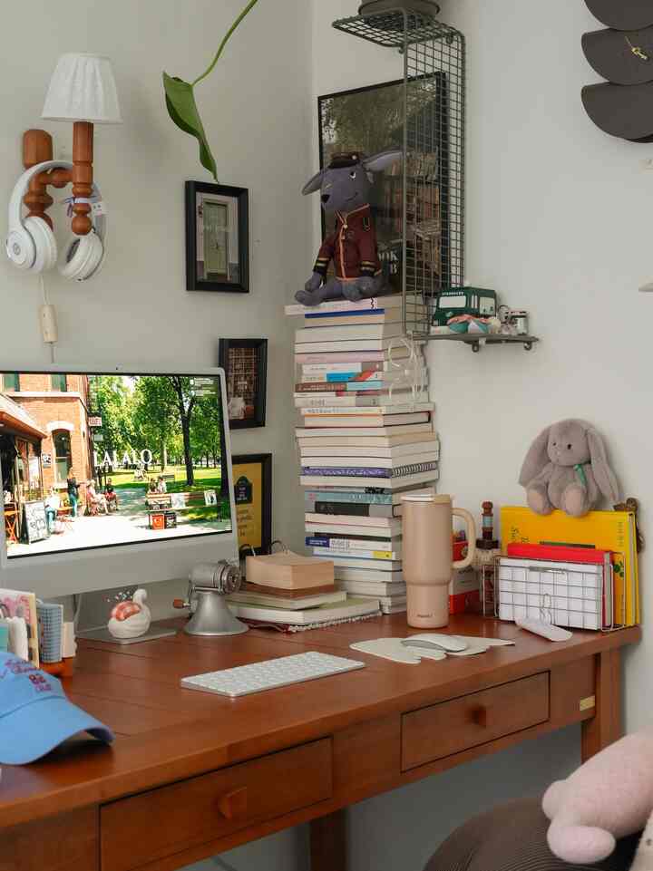 暖かみのあるブラウンの木製デスクが置かれたコンパクトなナチュラルトーンのホームオフィス、書籍や小物が配置され落ち着いた雰囲気のインテリア