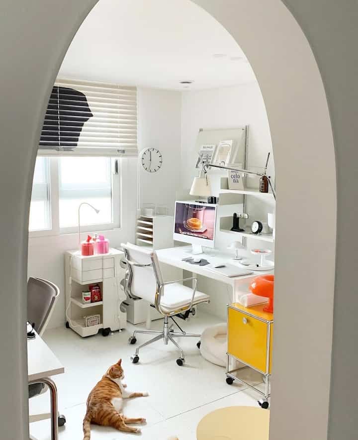 白を基調としたホームオフィス空間、猫とペット用品が配置された清潔で明るい雰囲気のインテリア
