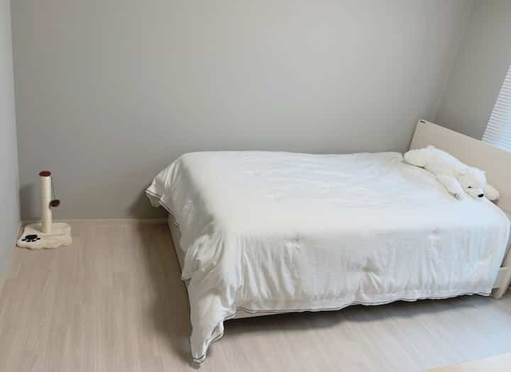 白と淡いグレーの色調の子供部屋、白いベッドと北極くまのぬいぐるみが置かれた温かみのある空間