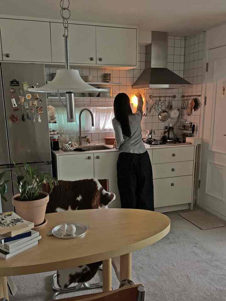 白と木目調が調和したキッチン、調理器具と冷蔵庫が配置された雰囲気のある空間