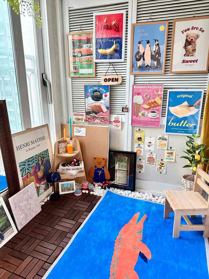 青いラグと木目調の床、子供用の木製椅子、カラフルなポスターが壁に配置された子供部屋のインテリア