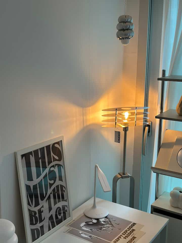 シルバーのフロアランプと白のテーブルランプが配置されたホワイトトーンのホームオフィス、ミニマルなインテリア