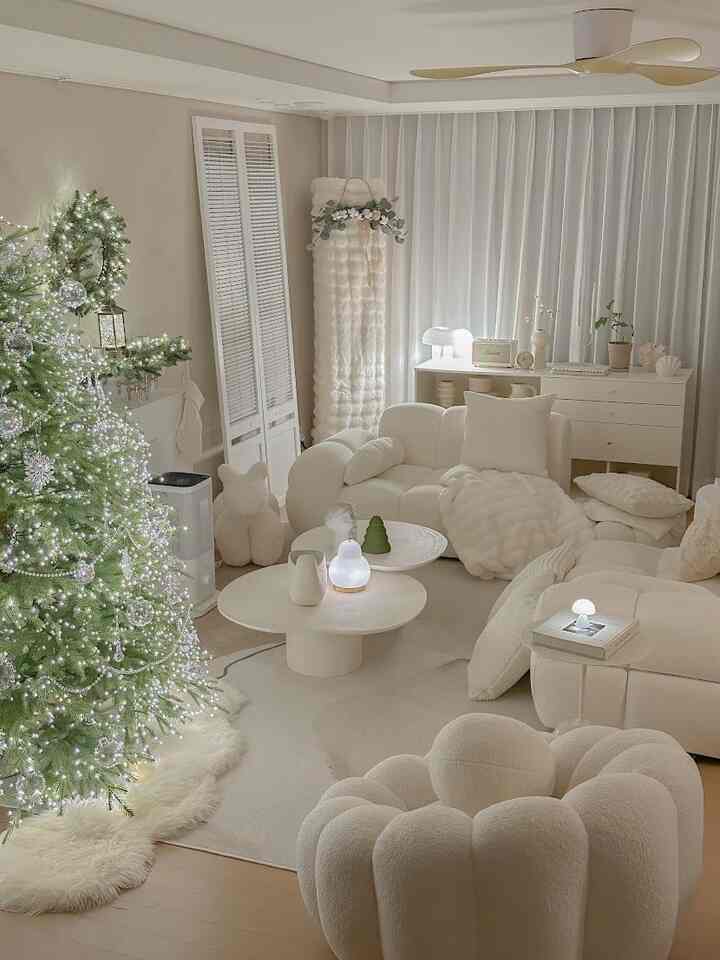 クリーム色とホワイトが調和した居心地の良いリビング、ブークレファブリックのソファとクリスマスツリーが配置された空間