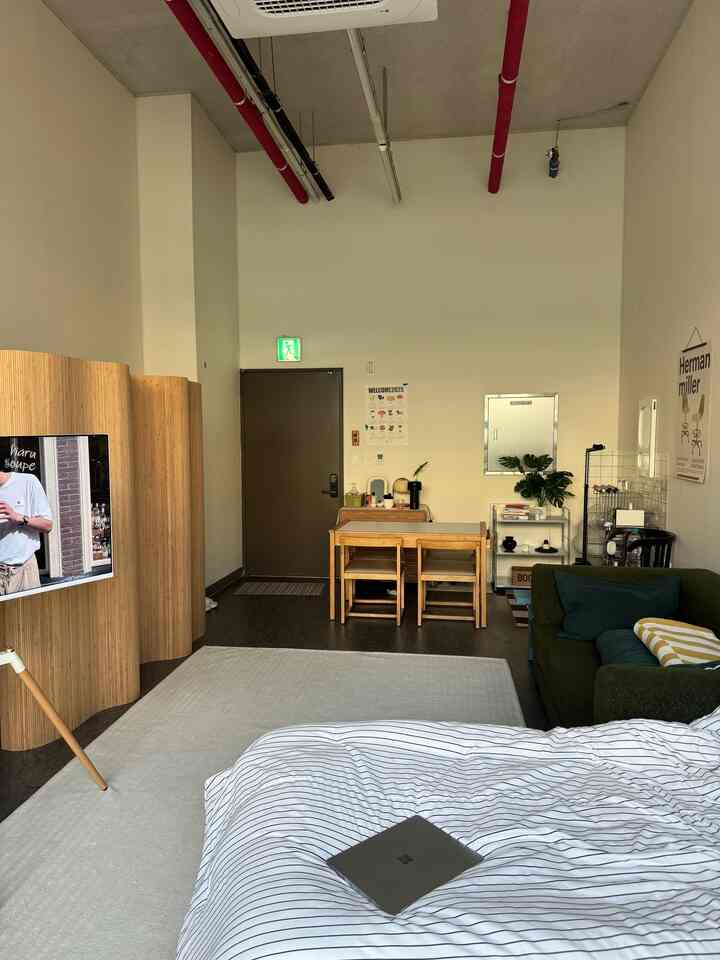 白と茶色のトーンが特徴の狭い部屋、ナチュラルモダンな家具と間仕切りが配置された雰囲気のあるホームオフィス