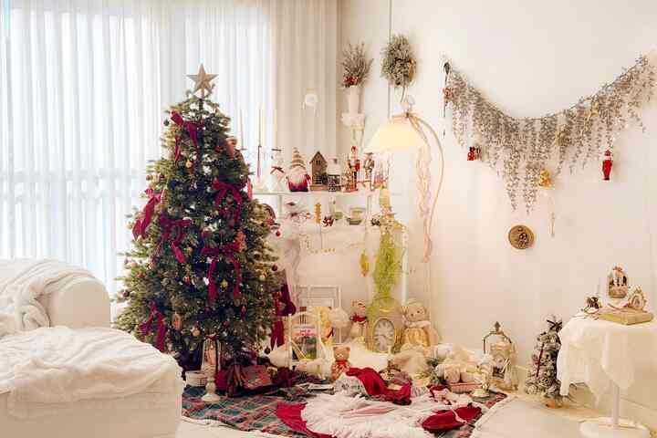 ホワイトとレッドの色調が調和したリビング、クリスマスツリーとヴィンテージ小物が配置された雰囲気のある冬の空間