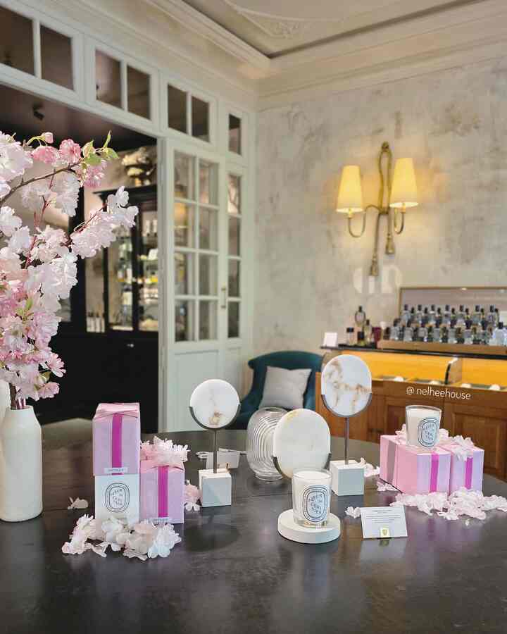 Cafe style space featuring a vase with flowers, candles, and marble objets in a serene and elegant interior