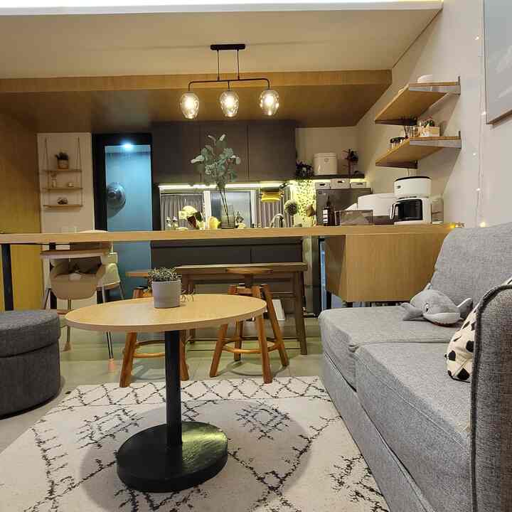 Natural modern living room and kitchen with bright wood tones and gray sofa creating a cozy atmosphere