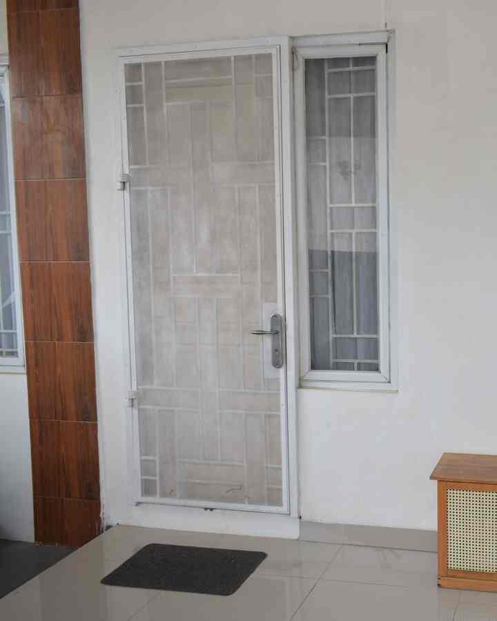 White door with wood tone wall paneling in a small entrance area, simple and clean atmosphere