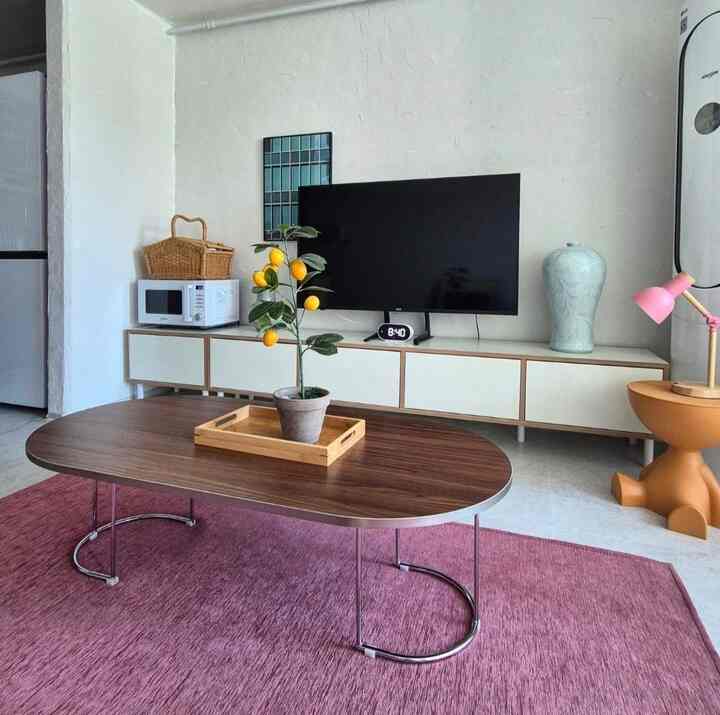 白と茶色のトーンのリビング、中央のコーヒーテーブルにレモンの植物とトレイが置かれたシンプルでモダンな空間