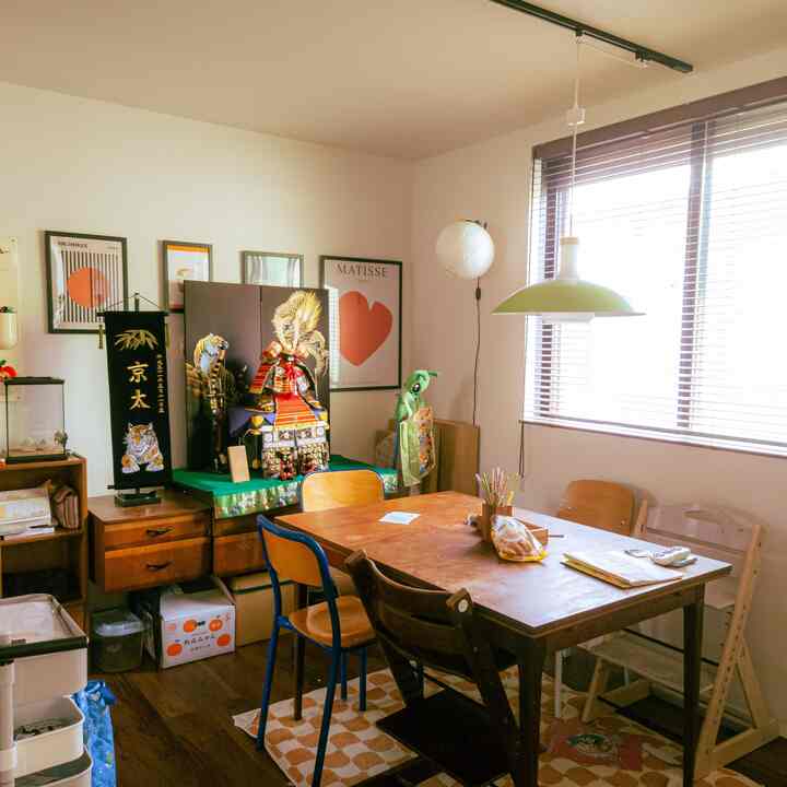 ブラウンの木目調と白い壁のダイニング、伝統的な鎧の飾りとヴィンテージ家具が置かれた雰囲気のある空間