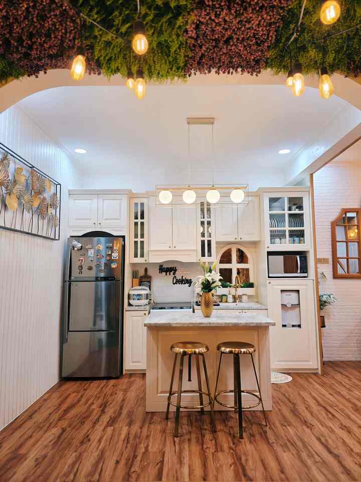 Classic kitchen in white and wood tones featuring gold bar stools and pendant lights, creating a cozy ambiance