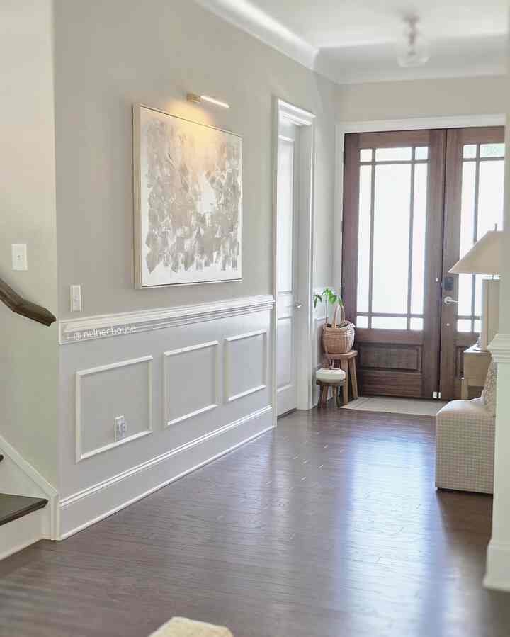 Natural-toned entrance featuring wooden side table, beige lamp, and bright clean atmosphere