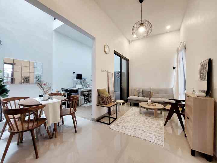 Bright white and brown-toned open floor plan living and dining room featuring natural wood furniture for a spacious and cozy atmosphere
