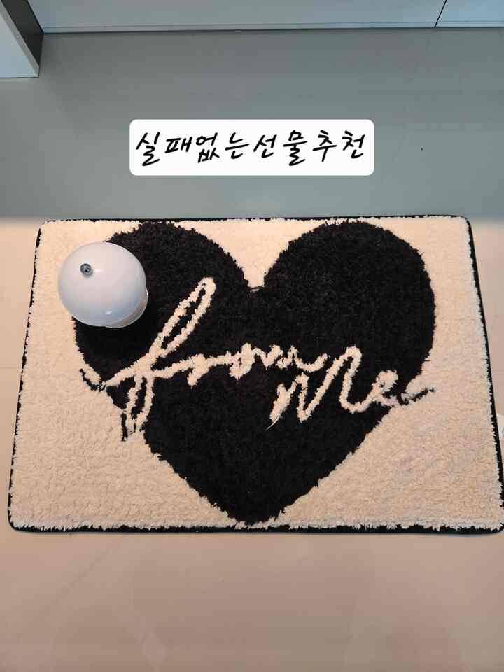 黒と白のハート型メモリーフォームバスマットが床に置かれたモダンなバスルームのインテリア