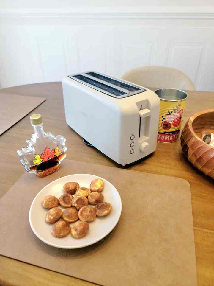 White and beige toned kitchen dining table featuring a toaster and food, creating a cozy atmosphere