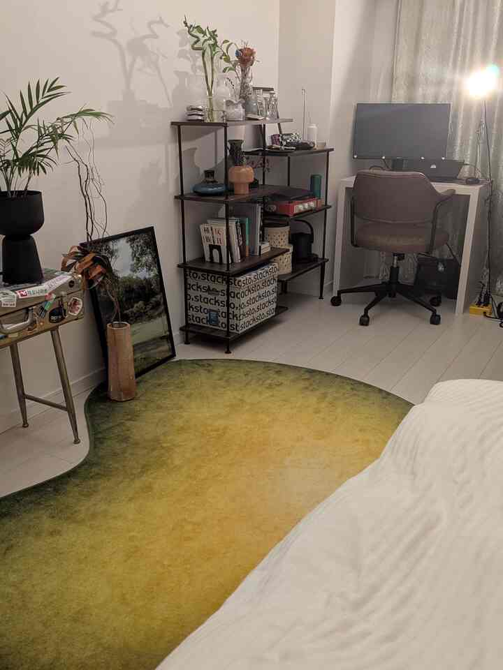 緑と黄色のグラデーションラグがあるホームオフィス、デスクとオフィスチェアが配置されたミニマルな空間