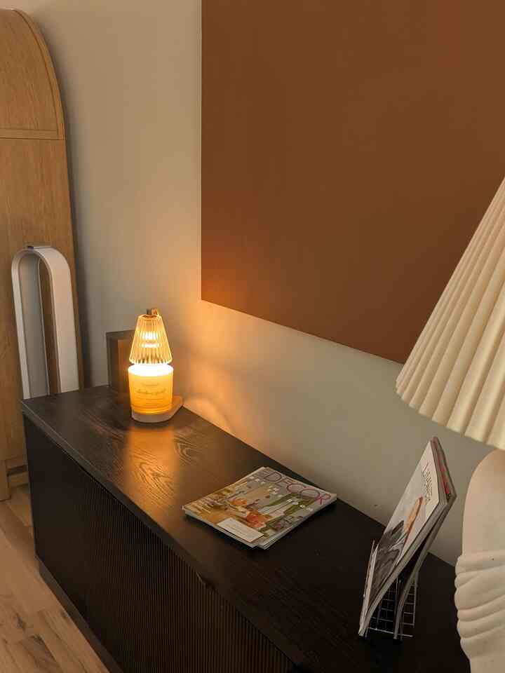 Cozy natural-toned space featuring warm lighting and candle on dark brown cabinet