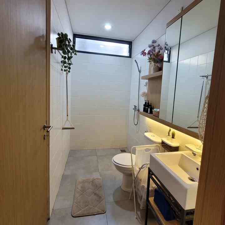 Bright natural-tone small bathroom featuring white tiles, wood-tone fixtures, and clean, spacious atmosphere