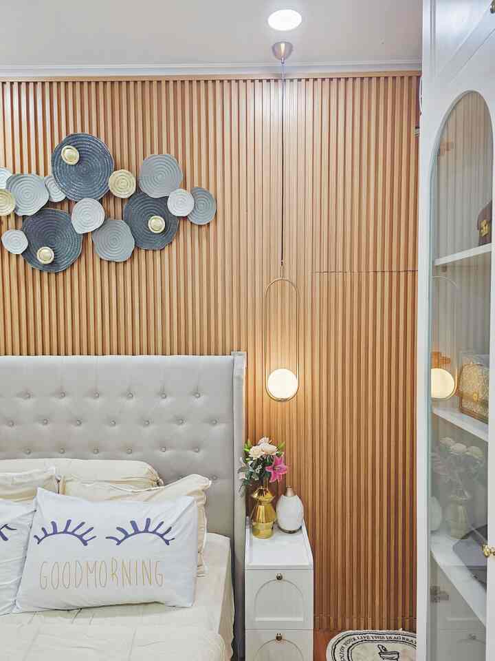 A beige and wood tone bedroom featuring gold accents and pendant lighting with a natural, harmonious interior design