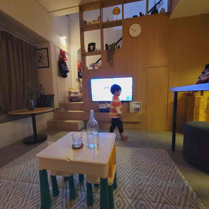 Wood tone and white living room featuring kids' furniture and TV with a cozy atmosphere