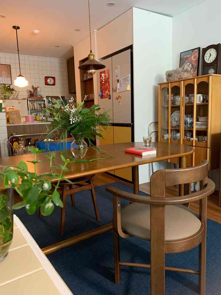 木目調とホワイトが調和するダイニング、中央に置かれた木製テーブルと花瓶が印象的な温かみのあるインテリア