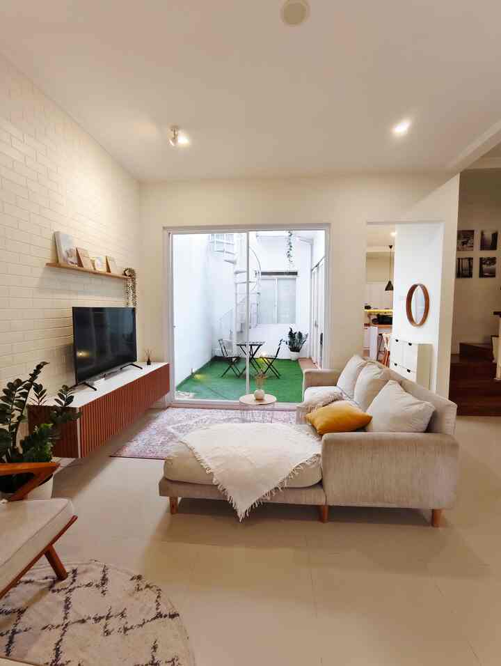 Bright living room in white and wood tones featuring natural sofa and floating cabinet with a cozy atmosphere