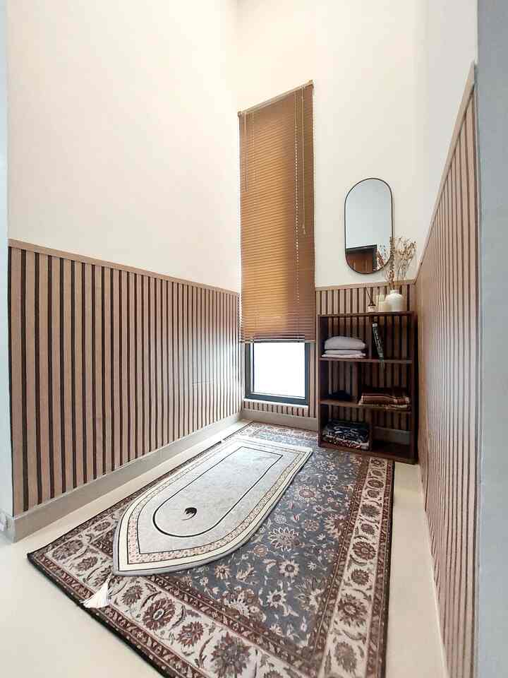 Beige and wood tone long narrow entrance space featuring a patterned carpet center floor, small mirror and shelving on the wall