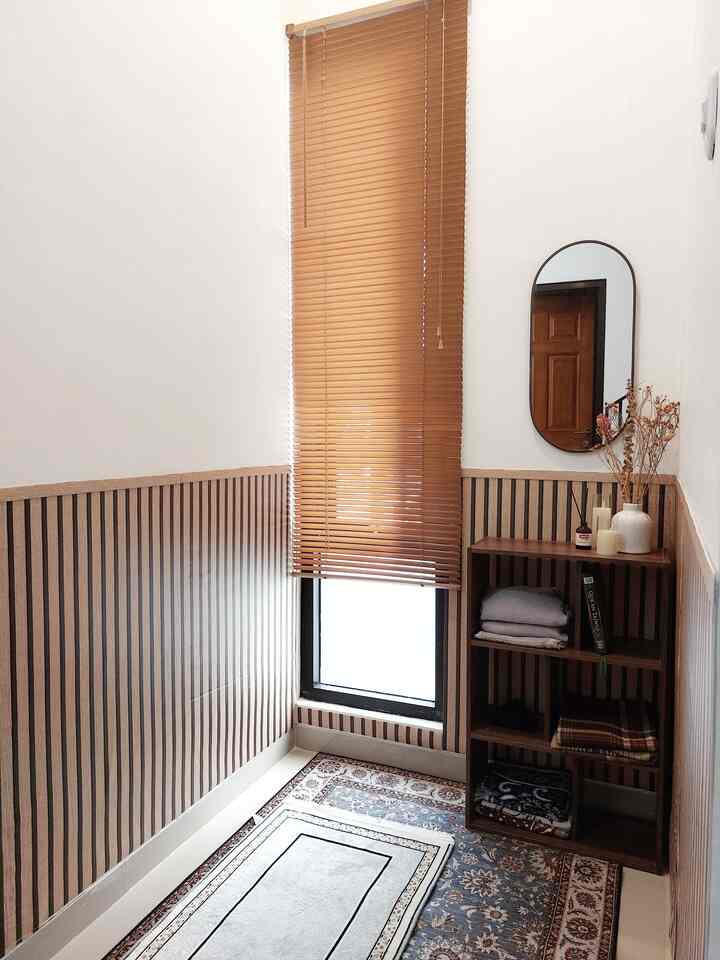 Natural small entrance space in wood tones and white, featuring blinds, decorative mirror, and storage cabinet with warm atmosphere