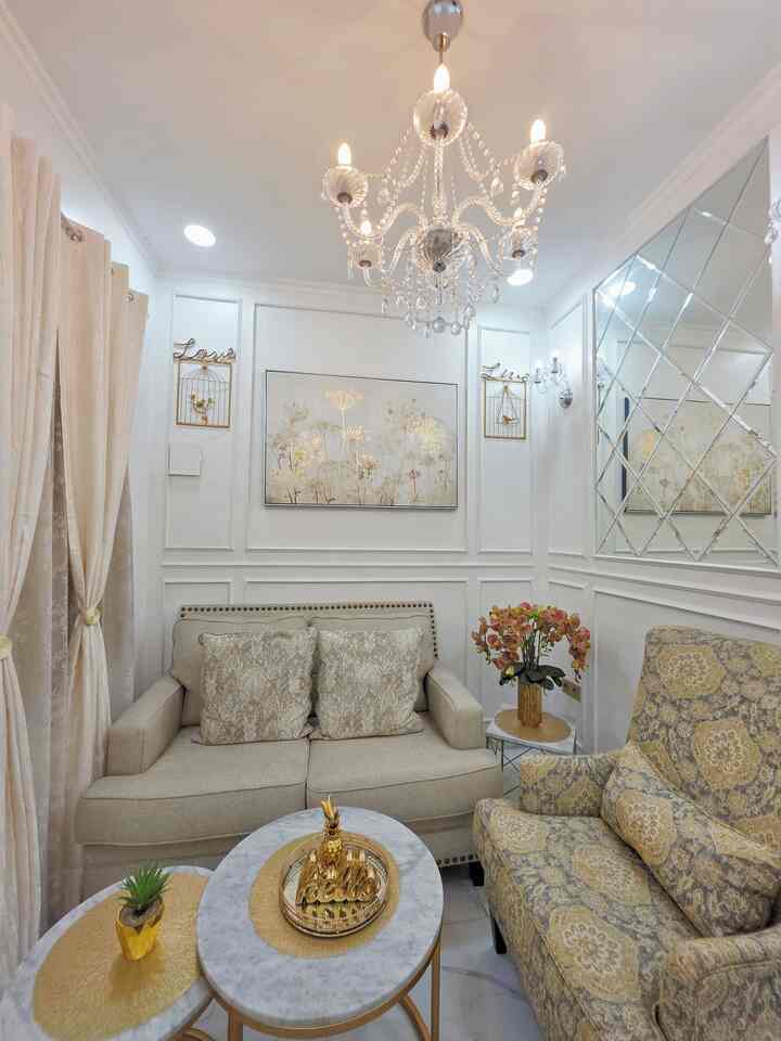 Bright beige and white toned living room featuring a beige sofa and patterned armchair in a natural modern style