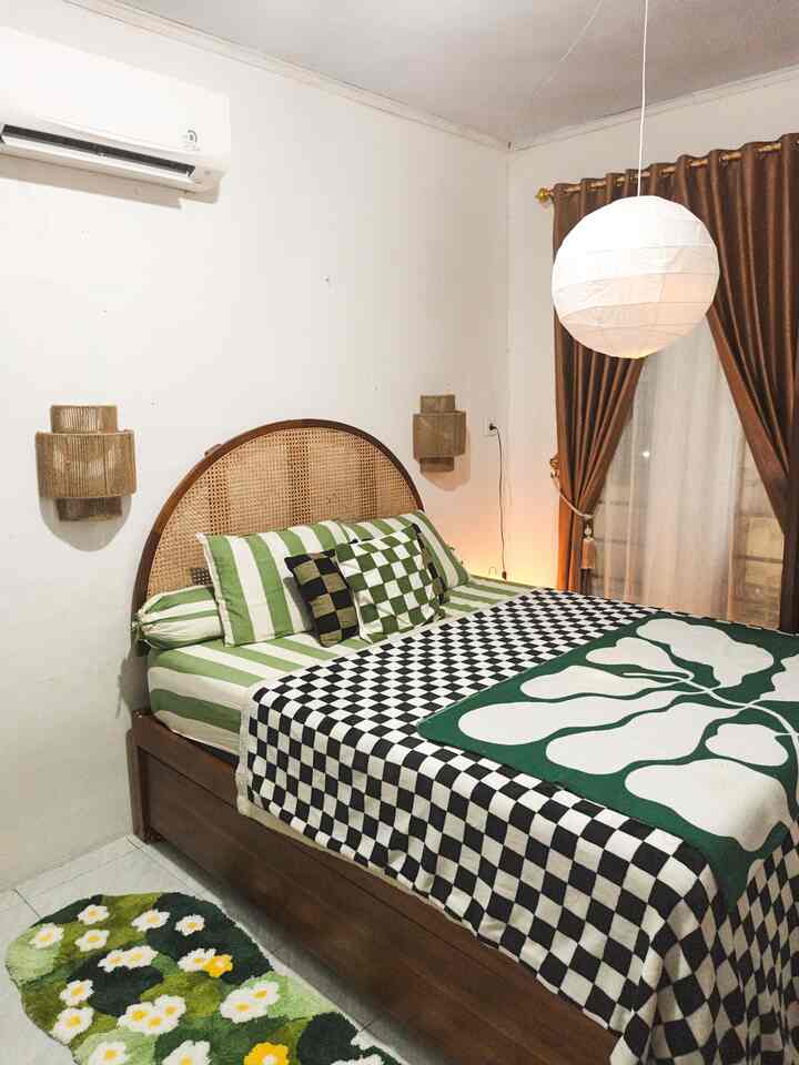 Kamar 3x4 namun tetap cozy dan fungsinya maksimal 🌿🌿🌿
Master bedroom di rumah kami berukuran 3 x 4 m, dengan luas yang terbatas kami berusaha memaksimalkan fungsinya dengan baik, salah satunya dengan custom dipan kasur sorong ini. untuk bagian bawahnya kami fungsikan untuk menyimpan kasur cadangan. Untuk penerangan di malam hari, kami menambahkan kap lampu dinding berbahan natural serta lampu meja dan lampu gantung  berbentuk lampion. Agar kamar ini terasa lebih cozy, pemilihan sprei bermotif lucu berbahan katun Jepang dengan warna yang fresh sangat membantu mood ketika terlelap tidur di malam hari, di samping tempat tidur kami juga menambahkan rug cantik hijau berbentuk taman bunga untuk kesan yang yang lebih segar. 
Di era gempuran kamar dengan walk in closet dan desain set kabinet lemari dan meja rias yang serasi. Kami masih mempertahankan lemari jadul yang memiliki cermin, drawer penyimpanan serta meja rias bekas yang masih layak untuk kami pakai. Dengan penambahan rak kosmetik mini , membuat meja rias masih bagus untuk di tata. 
Jadi, menata kamar dengan furniture seadanya bukanlah halangan untuk membuat kamar kalian menjadi lebih aesthethic, jangan terlalu impulsif tapi tetaplah berkreasi dengan furniture yang seadanya, apalagi kondisiny yang masih bagus dan masih bisa di pakai. 
#bedroomstyling #inspirasikamar #kamartidurnyaman #walldecor #lampudinding #rug #sprei #dipan #throwblanket #lampugantung