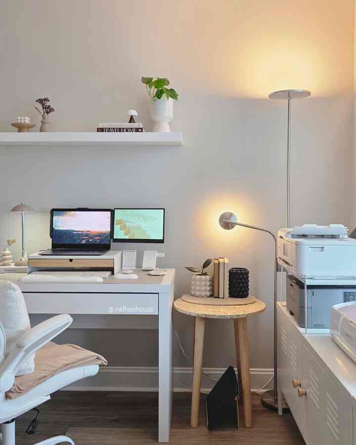 White and wood tone home office featuring a white desk and floor lamp with a modern and simple interior