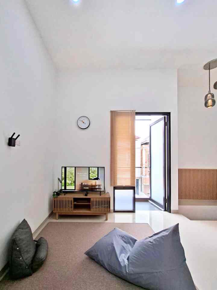 White and wood-tone small living room featuring a TV and bean bags with a modern atmosphere
